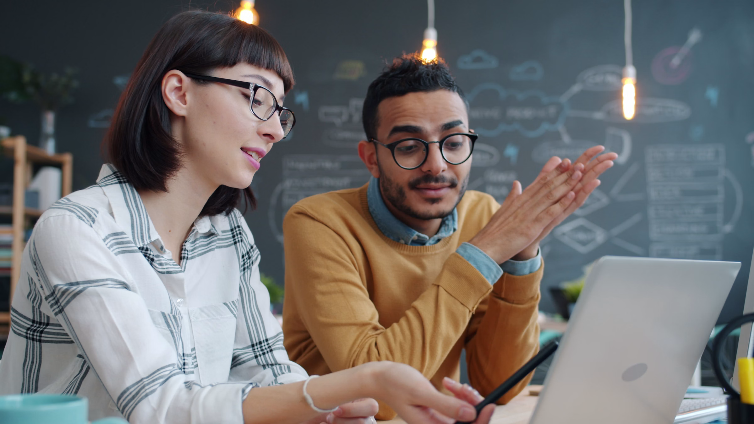 Business colleagues discussing work around a laptop representing CRM and ERP process friction